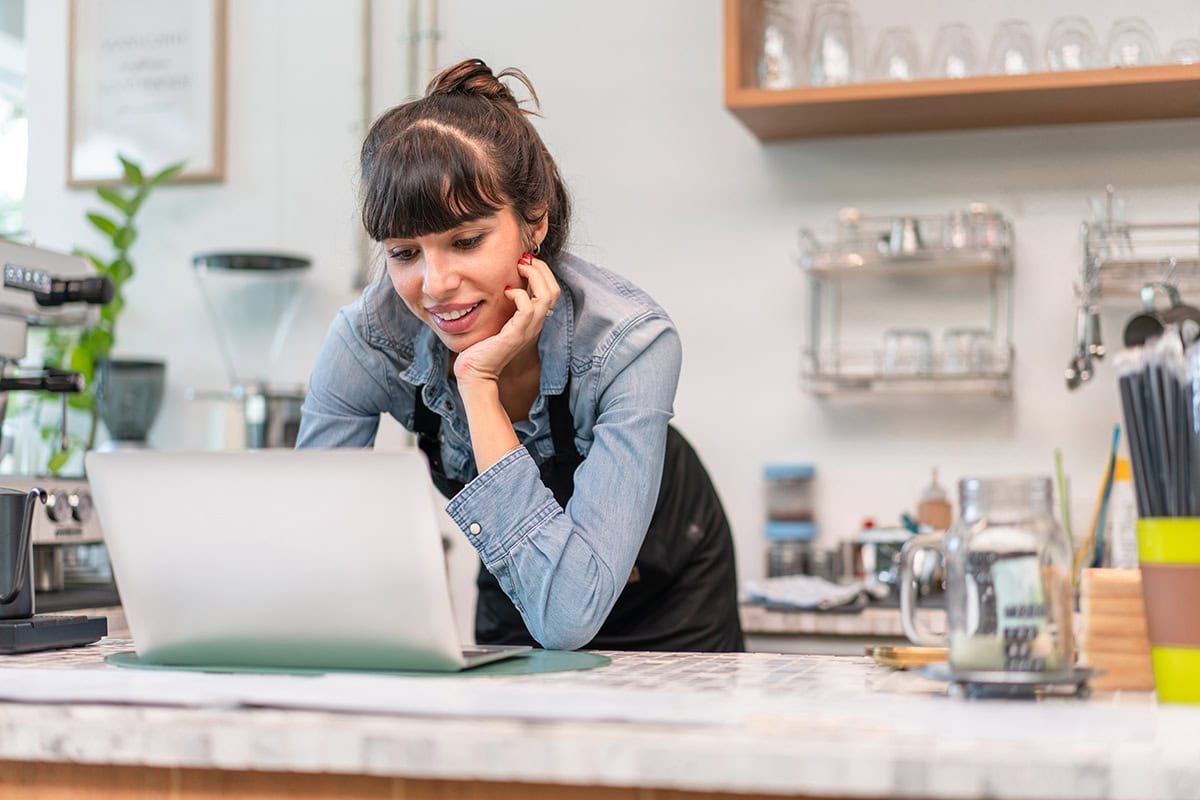 Young woman working on a laptop in a modern cafe or workspace.